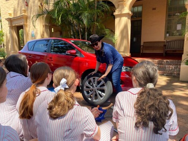 Des étudiantes apprennent à réparer une voiture