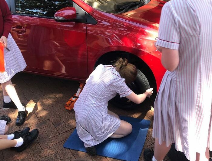 Des étudiantes apprennent à réparer une voiture